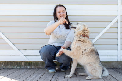 Portrait of young woman sitting with dog