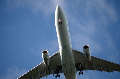 Low angle view of airplane flying against sky