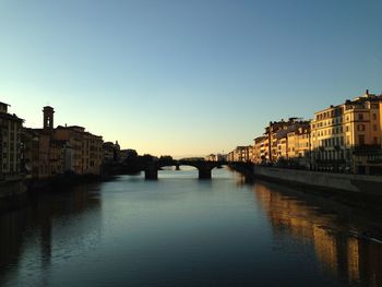 Arch bridge over river against buildings in city