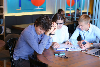 Female friends using laptop at table