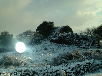 Scenic view of snow covered land against sky