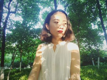 Low angle view of woman standing against trees