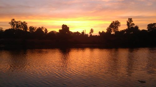 Scenic view of lake against orange sky