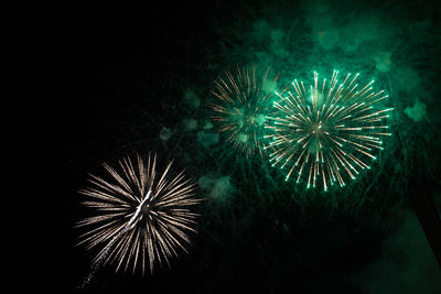 Low angle view of firework display at night