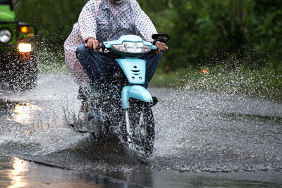 Man riding bicycle on wet road