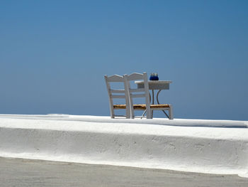 Low angle view of empty chair against blue sky