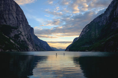 Scenic view of sea by mountains against sky