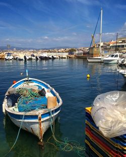 Boats moored at harbor against sky