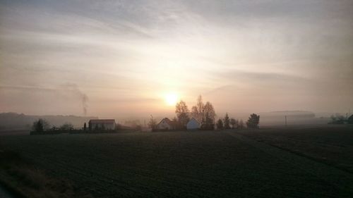 Scenic view of field against cloudy sky