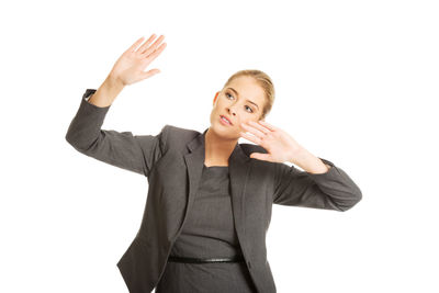 Smiling young woman standing against white background