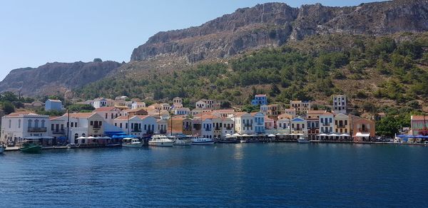 Scenic view of sea by buildings against clear sky