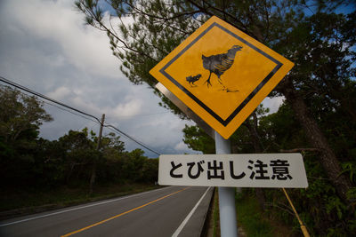 Information sign by road against sky