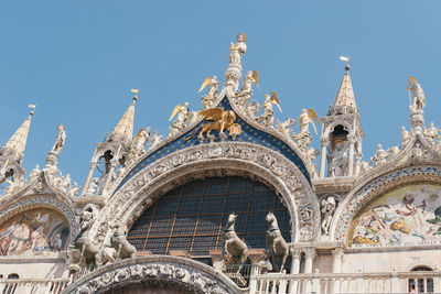 Low angle view of statue of historic building against sky