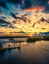 Scenic view of sea against dramatic sky during sunset