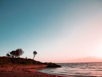 Scenic view of beach and sea against clear sky during sunset 