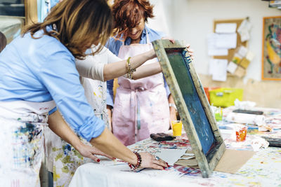 Group of artists creating fabric print with stencil