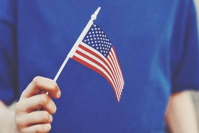 Midsection of person holding american flag