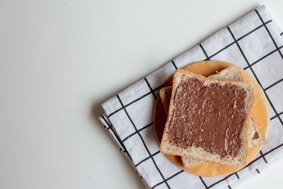 High angle view of bread in plate against white background