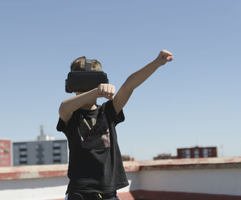 Low angle view of man with hands against clear sky