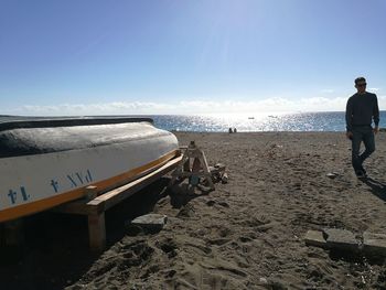 Rear view of people on beach against sky