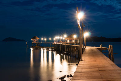 Pier in sea at sunset