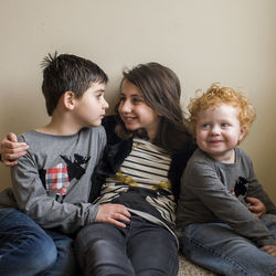 Siblings sitting happily together on floor at home