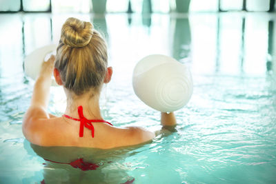 Rear view of woman in swimming pool