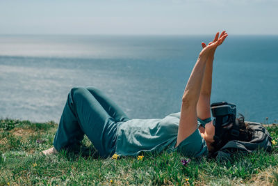 Adult woman lies mountain against the background  sea in summer, spring virtual reality glasses vr