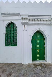 House's green wooden door and window in the medina of asilah