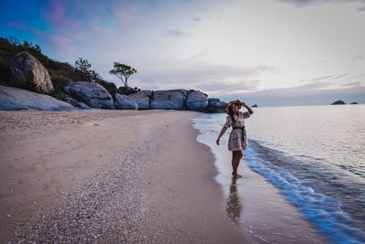 Woman on beach against sky