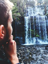 Portrait of man splashing water in forest