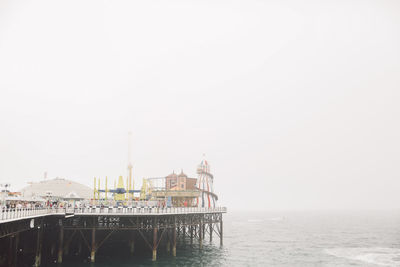 Brighton pier over sea against clear sky