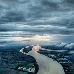 Aerial view of city by sea against sky