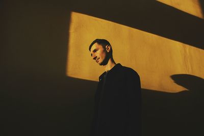 Low angle view of man standing against wall