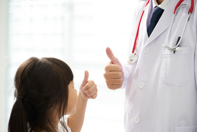 Doctor and girl gesturing thumbs up