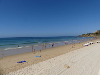 Scenic view of beach against clear blue sky