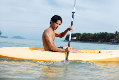 Man surfing in sea against sky