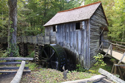 Watermill amidst trees at forest