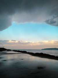 Scenic view of beach against sky at sunset