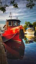 View of red ship in water against sky