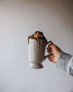 Hand holding coffee cup against white background