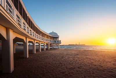 Bridge over sea against sky during sunset