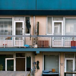 Man sitting on street against building in city