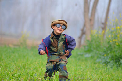 Portrait of boy standing on grassy field