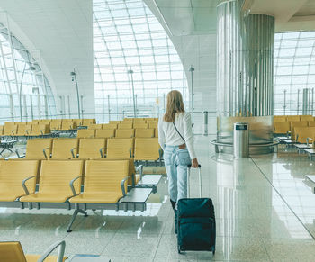 Rear view of woman walking at airport