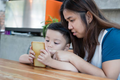 Mother and daughter while using smart phone