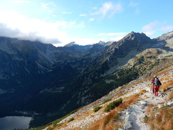 Rear view of people on mountain against sky