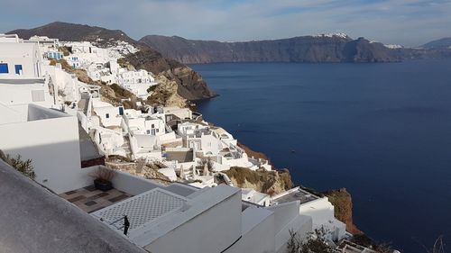 High angle view of townscape by sea against sky