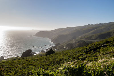 Scenic view of sea and mountains against clear sky