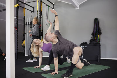 Happy people exercising together in gym